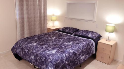 a bedroom with a purple bed and two night stands at 2 Beds & Bath Private Unit Free Parking Near Rainier Beach Light Rail And Bus Stop in Seattle