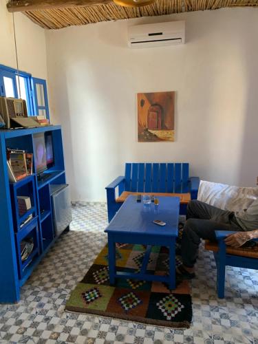 a living room with a blue table and a couch at Chez Youssef in Merzouga