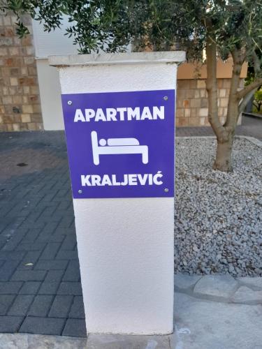 a blue and white sign on the side of a street at Apartman Kraljević in Ljubuški