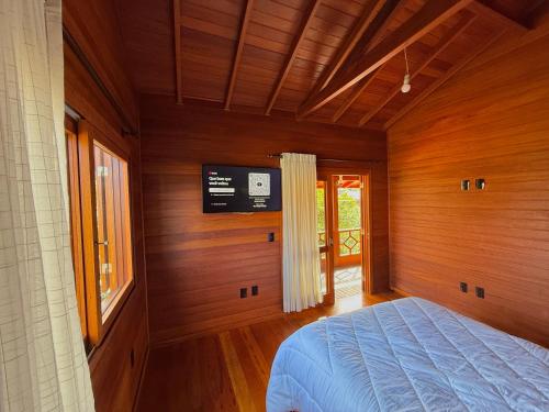 a bedroom with a bed and a tv on the wall at Casa espaçosa na Guarda do Embaú in Palhoça