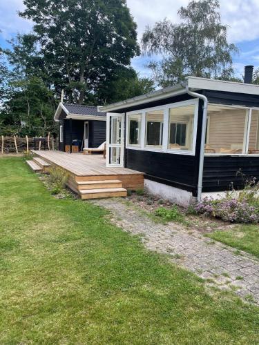 a small house with a porch and a deck at Modern and cozy holiday home in Jægerspris