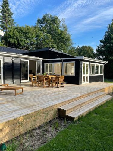 a house with a deck with a table and chairs at Modern and cozy holiday home in Jægerspris
