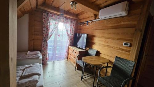 a small room with a bed and a table and chairs at Wyspa Kampinos in Wólka Smolana