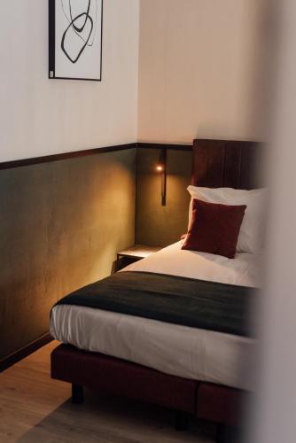 a bedroom with a bed with a red pillow at Getaway Studios Liège in Liège