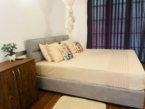 a bed with pillows on it in a bedroom at Mashi's Villa in Sigiriya