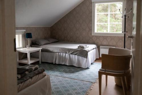 una camera da letto con un letto, una sedia e una finestra di Villa Iris, Nagu a Finby