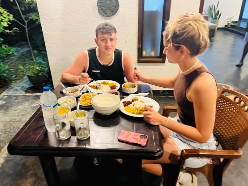 a man and a woman sitting at a table eating food at Mashi's Villa in Sigiriya