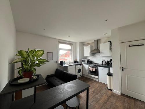 a kitchen and living room with a couch and a table at Cozy hotel-style city apartment in Amley