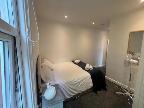 a small bedroom with a bed with white sheets at Cozy hotel-style city apartment in Amley