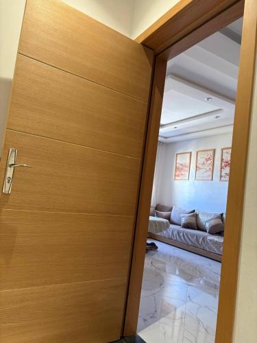 a wooden door leading into a living room with a couch at apparemment sea view 01 in Tangier
