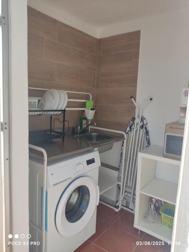 a laundry room with a washing machine and a sink at Mi Rinconcito in Chipiona