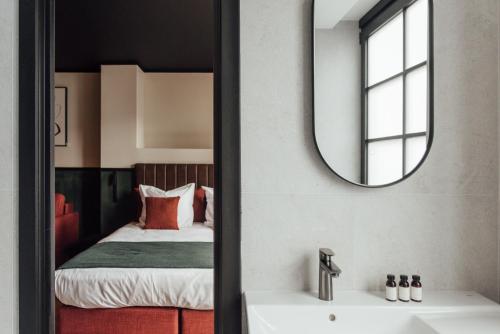 a bathroom with a mirror and a bed at Getaway Studios Liège in Liège