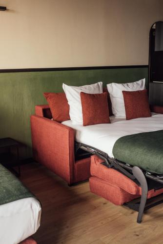 a bedroom with a large bed and a couch at Getaway Studios Liège in Liège