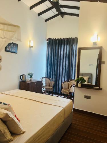 a bedroom with a bed and a mirror and a table at Mashi's Villa in Sigiriya