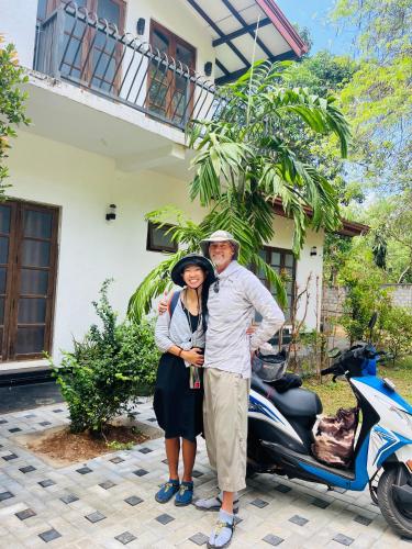 a man and a woman standing next to a scooter at Mashi's Villa in Sigiriya