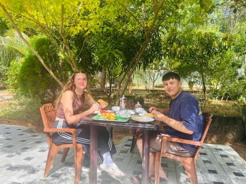 a man and woman sitting at a table eating food at Mashi's Villa in Sigiriya