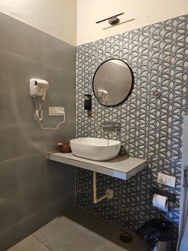 a bathroom with a sink and a mirror on a wall at ilika Resort, Pauri in Pauri