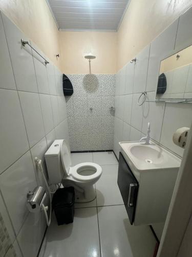 a white bathroom with a toilet and a sink at Capitólio 05 Hospedagem em Canoa Quebrada Ce in Canoa Quebrada