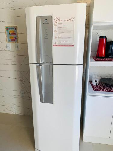 a white refrigerator in a kitchen next to a counter at kitnet dos Sonhos in Florianópolis