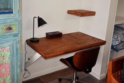a desk in a room with a lamp and a chair at Hummingbird Villa in Saint Johnʼs