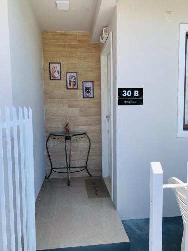 a hallway with a table and a sign on the wall at kitnet dos Sonhos in Florianópolis