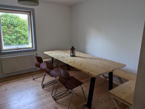a wooden table and chairs in a room with a window at Ferienhaus in Borghamn, Vättern in Borghamn