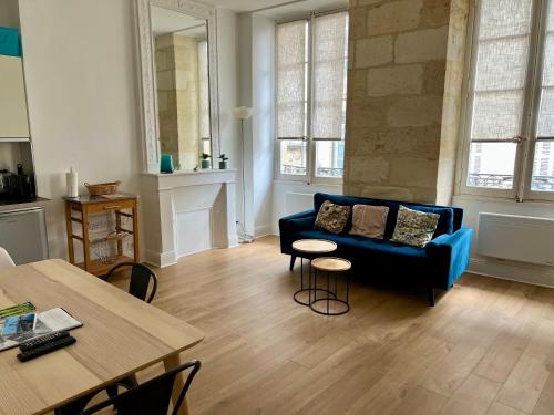 un salon avec un canapé bleu et une table dans l'établissement alsace, à Bordeaux