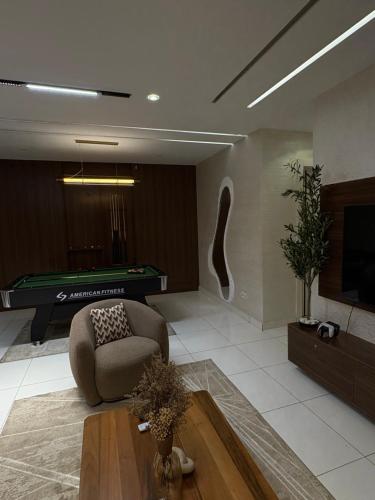 a living room with a couch and a pool table at Cozy, Serene Ambiance With Nice Balcony Views in Ikate