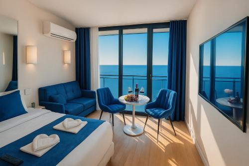 a hotel room with a bed and a table and chairs at ORBI CITY Luxe Suites Hotel in Batumi