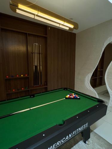 a pool table in a room with a green at Cozy, Serene Ambiance With Nice Balcony Views in Ikate