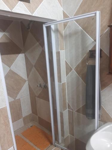 a shower with a glass door in a bathroom at AD'S Overnight Accommodation in Richards Bay