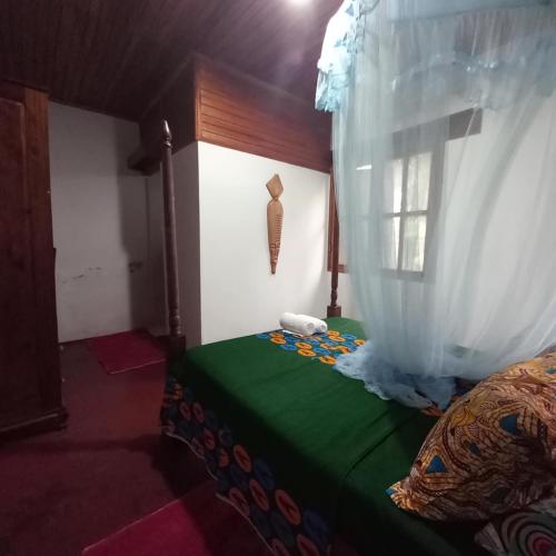 a bedroom with a bed with a curtain and a window at Mionga in Santa Cruz