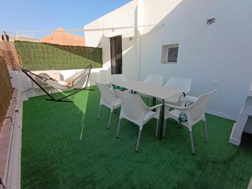 a table and chairs on a balcony with green grass at Luz de Calma in Tabernas