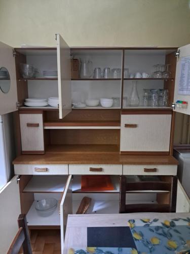 a kitchen with a cupboard with dishes on it at Les VIGNEAUX Hautes Alpes, Appartement 4 personnes, avec belle terrasse panoramique in Les Vigneaux