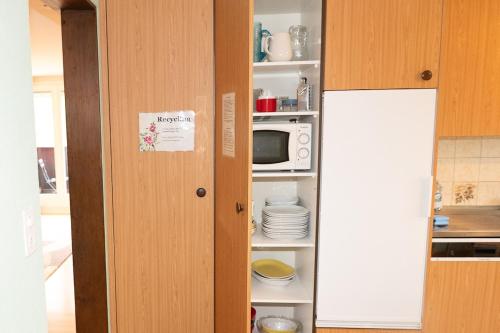 a kitchen with a pantry with a microwave and a door at BnB Ilfis Wohnung Nr 2 in Langnau