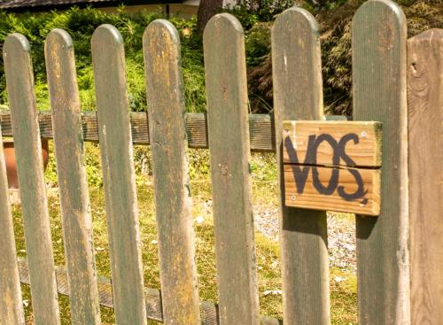 a wooden sign on a fence with graffiti on it at Home 6P Bath-Garden house-4G Pool-Kids-Dog in Hoenderloo