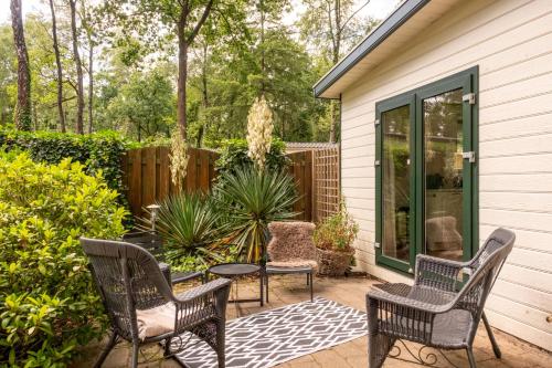 a patio with four chairs and a table and a table at Home 6P Bath-Garden house-4G Pool-Kids-Dog in Hoenderloo