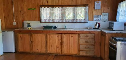 a kitchen with wooden cabinets and a sink and a window at Viva O Sonho 