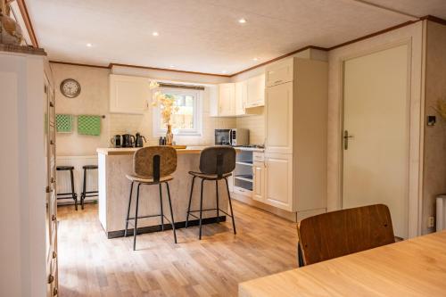 a kitchen with a counter and two stools at Home 6P Bath-Garden house-4G Pool-Kids-Dog in Hoenderloo