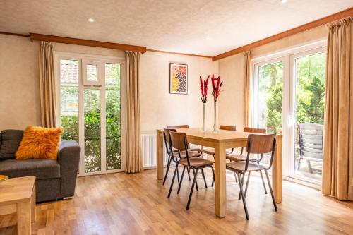 a dining room with a table and chairs at Home 6P Bath-Garden house-4G Pool-Kids-Dog in Hoenderloo
