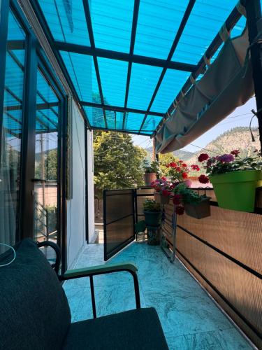 a balcony with potted plants and a blue ceiling at happy home in Borjomi