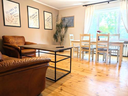 a living room with a table and chairs and a dining room at SB Apartment with Sauna in Kołobrzeg