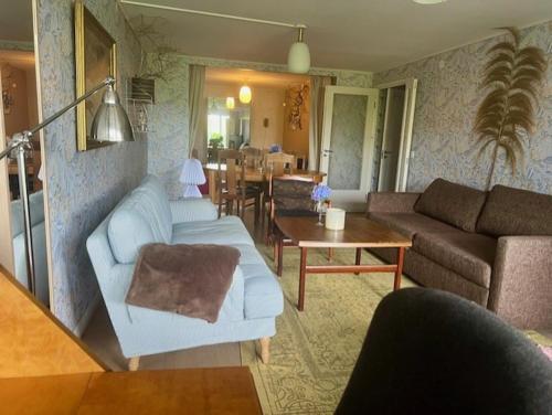 a living room with a couch and a table at Beautiful rooms in a charming Båstad villa top location near the beach and town center in Båstad