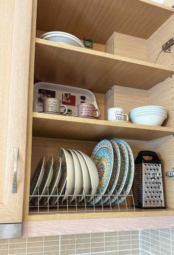 a cabinet with plates and cups and bowls on it at Madou house in Leonidion