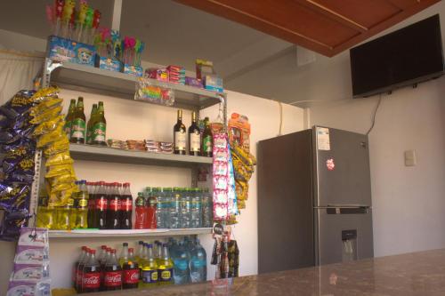 a room with a refrigerator and lots of soda bottles at Bungalows Rupay Wasi in Los Órganos
