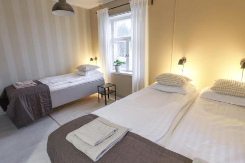 two beds in a room with a window at Hotel Merikruunu in Dragsfjärd