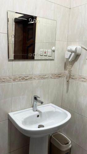 a bathroom with a white sink and a mirror at شقق النورس in Rayyis