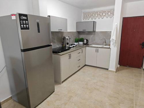 a kitchen with a stainless steel refrigerator and white cabinets at קסם הכנרת in Tiberias