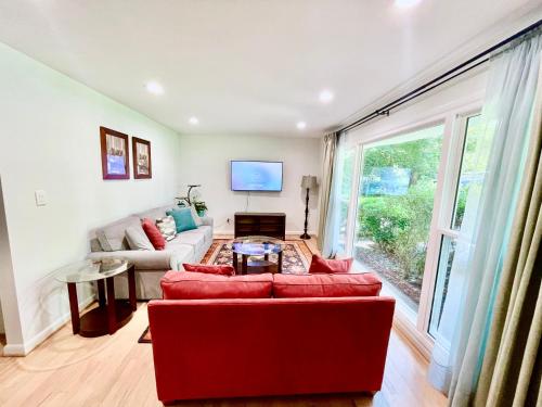 a living room with a red couch and a large window at Oak House in Silver Spring