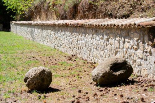 two large rocks sitting next to a stone wall at B&B Nonna Iolanda in Camigliatello Silano